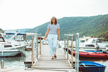 Fototapeta premium woman in white fashion luxury view walking by dock boats on background