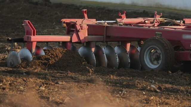 Tractor plowing agricultural land, slow motion from 120 fps footage