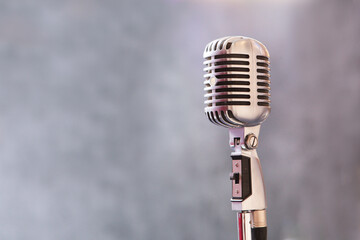 Retro microphone on a gray background. Night club and entertainment. Close-up. .The performance on the stage.