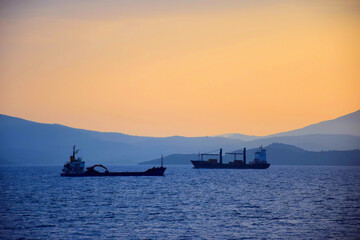 Fototapeta premium cargo ship travels at sunset