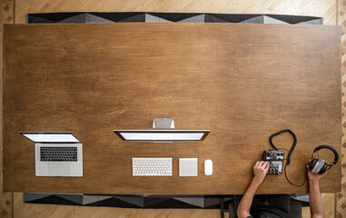 Top view of wooden desktop with male hands and computers copy space