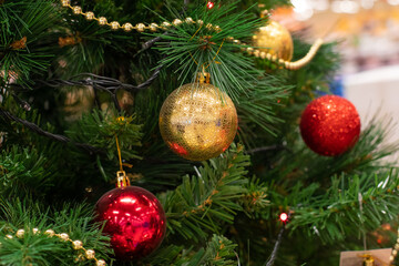 Christmas tree decorated with shining red gold balls close-up. Festive Christmas background design