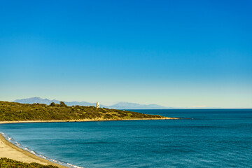 Coast with sandy beach and lighthouse, Spain.