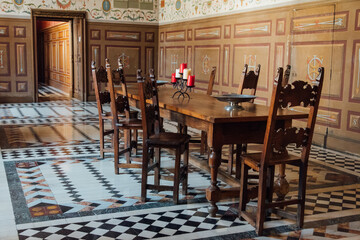 vieille salle  à manger avec une table en bois et des chaises anciennes. Intérieur du château d'Ancy-le-franc