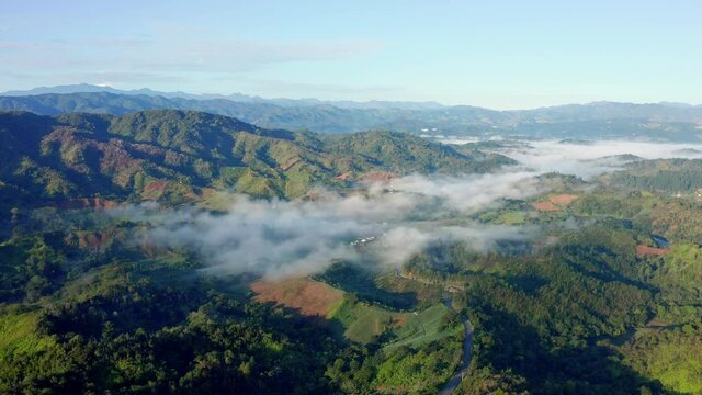Aerial shot with drone over the beautiful colorful Mountains of Constanza, Dominican Republic, dazzling the clouds and mist on a clear and cold morning