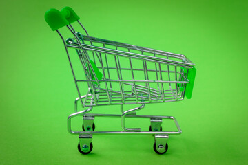 Shopping trolley on the green background