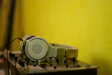 headphones in the foreground on top of a sound console