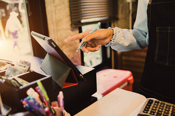 Employees are using hands to calculate expenses from the machine to collect money in the coffee...