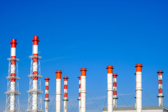 A Lot Of White And Red Industrial Pipes Against The Background Of A Cloudless Blue Sky On A Sunny Day.