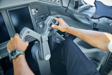 Male pilot in cockpit flying passenger plane