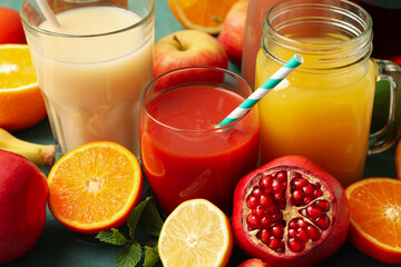 Concept of glasses and jars with different juices on green background