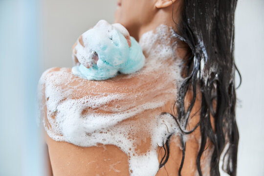 Brunette Young Woman Washing Body With Exfoliating Bath Sponge