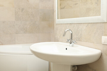 Sink in modern comfortable bathroom in light beige color