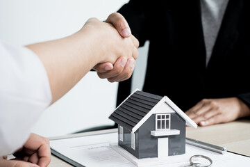 Businessmen and brokers real estate agents shake hands after completing negotiations to buy houses...