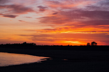 Naklejka premium Colorful sunset on a beach with water and sky. Summer landscape background. Beautiful natural landscape.