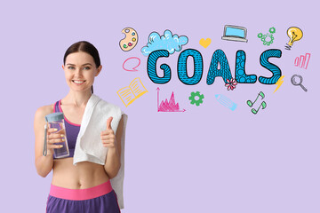 Sporty young woman with bottle of water and word GOALS on color background