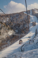 Area of Kiroro ski resort. Skiers and Snowboarders Ride the Gondola at Kiroro Ski Resort during winter with fully of snow ground in Hokkaido, Japan.
