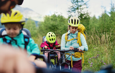Family with small children cycling outdoors in summer nature, resting.