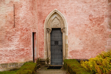 Fragment of a medieval facade with a gothic door. Historic Christian monastery Golden Crown Zlata Koruna, South Bohemia, Czech Republic