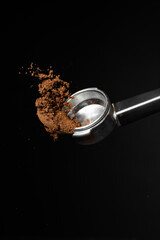 Portafilter with coffee powder on dark background