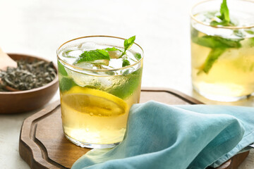 Glass of tasty cold ice tea on table