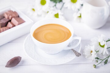 Autumn mood. Coffee with milk, gourmet chocolates and chrysanthemums flowers on a white background
