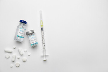 Bottles of insulin with syringe and pills on white background. Diabetes concept
