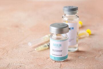 Bottles of insulin with syringes on color background. Diabetes concept
