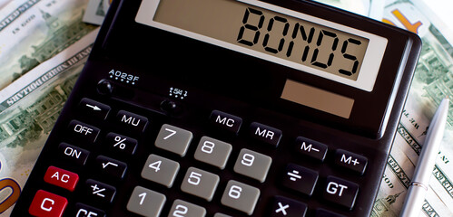Calculator with text BONDS on the dollars. Business, finance conceptual.