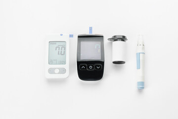 Glucometers and lancet pen on white background. Diabetes concept