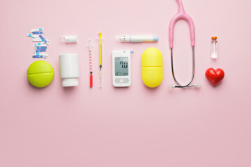 Glucometer with medications, stethoscope, syringes and lancet pen on color background. Diabetes...