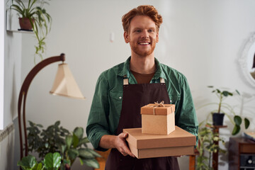 Crafter in mask holding gift boxes