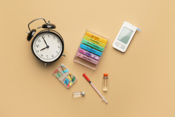 Glucometer with medications, syringe and alarm clock on color background. Diabetes concept