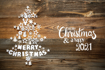 White Little Christmas Decoration Items Building Christmas Tree Including Word Merry Christmas. English Text Merry Christmas And A Happy 2021. Brown Rustic Wooden Background