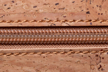 Zip fastener background texture. A high-resolution closeup of a detail from a closed plastic zip fastening on a handbag made of natural cork. Macro photo.