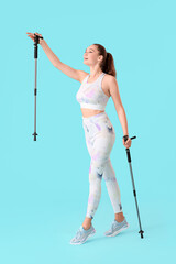 Young woman with walking poles on color background