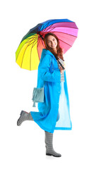 Beautiful young woman in raincoat and with umbrella on white background