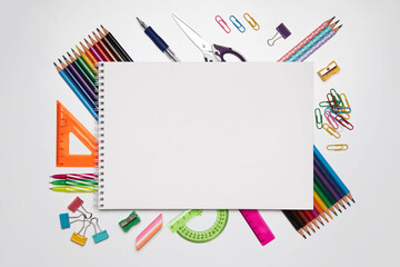 Colored school supplies for learning on a white background. Back to school. Pens, rulers, pencils and paper clips. Flat lay, top view, copy space