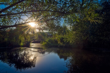 Sun over small arched bridge