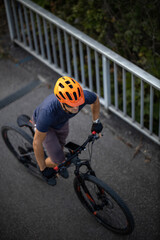 Naklejka premium Cross country mtb biker going for his favorite hills beyond the city limits (top view; shallow DOF)