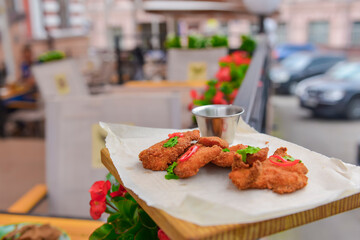 Mixed deep fried appetizer with dip sauce. Fried chicken, beer snack with dip sauce served on a wooden board.