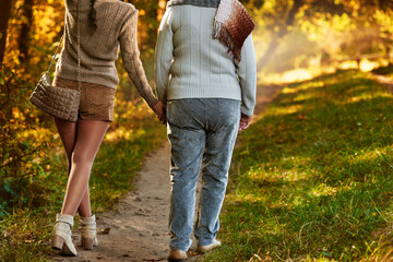 Back view photo of mother and daughter walking in autumn park