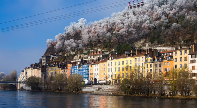 Image of cable cars over river and bridge in Grenoble in autumn, France