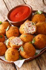 Deep fried sauerkraut balls with ham close-up in a plate on the table. vertical