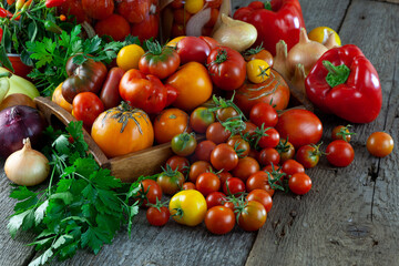 Tomatoes, peppers, onions on the table. Preservation of the autumn harvest of vegetables. Glass jar with pickled tomatoes. Wooden background. Vegetable food. Still life. Tomato of different varieties.