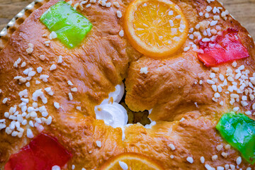 Christmas round fruit cake decorated with fir tree branch, glazed fruits and nuts
