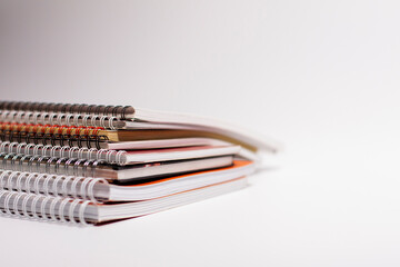 A pile of notebooks with bound pages. Side view.