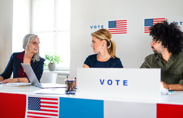 Members of electoral commission talking in polling place, usa elections.