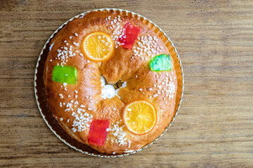 Christmas round fruit cake decorated with fir tree branch, glazed fruits and nuts