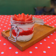 Dessert panna cotta with fresh strawberries served in a glass, selective focus. Delicious fruit...